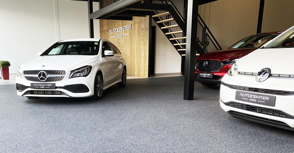 Grijze grindvloer in de showroom van Autocenter Oss met Mercedes en Volkswagen