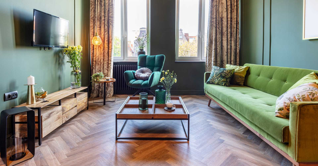 PVC visgraatvloer in een woonkamer met groene bank en houten tv-meubel