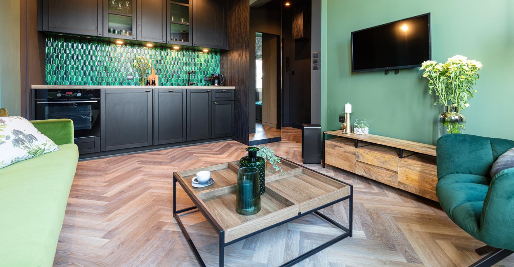 PVC vloer in visgraatmotief in een woonkeuken met groene wand en zwarte keuken